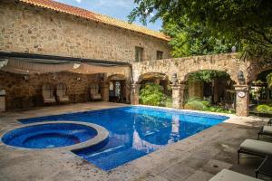 a swimming pool in front of a stone house at Quinta Real Guadalajara in Guadalajara
