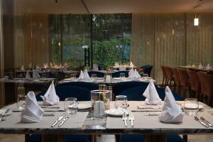 a dining room with tables with white napkins on them at Hotel Supreme in El Biar