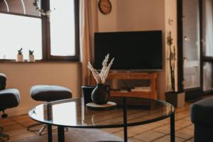 a living room with a glass table and a tv at Ferienwohnung Südblick in Barntrup