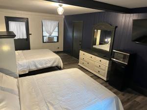 a bedroom with two beds and a dresser and a mirror at Keyes Motel in Arlington Heights