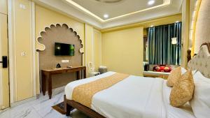 a hotel room with a bed and a television at Hotel Shree Banke Bihari Heritage in Maheshwar