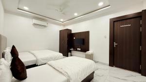 a hotel room with two beds and a tv at Hotel Shree Banke Bihari Heritage in Maheshwar +6 photos