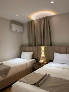 a hotel room with two beds and a window at Sama Al Sweifieh - سما الصويفية in Amman