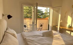 a bedroom with a bed and a view of a balcony at Poggio Madonna in Campagnatico