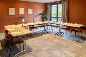 a conference room with wooden tables and chairs at Best Western Plus Hôtel de Robien in Saint-Brieuc