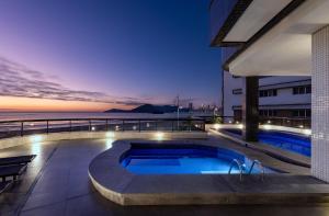a pool on the roof of a building at night at Hotel D'sintra in Balneário Camboriú