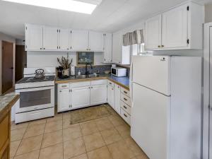 a kitchen with white cabinets and a white refrigerator at MTN Meadow Retreat near PC in Peoa