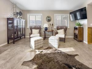 a living room with two chairs and a flat screen tv at MTN Meadow Retreat near PC in Peoa