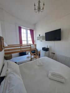a bedroom with a large white bed and a tv at The West Pier Residence in Brighton & Hove