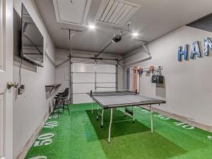 a ping pong table in a room with green flooring at Norman Home with Game Room in Norman