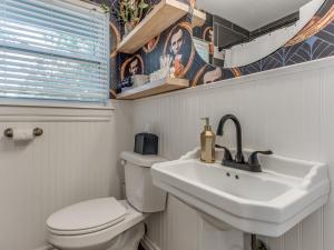 a bathroom with a white toilet and a sink at Norman Home with Game Room in Norman +18 photos
