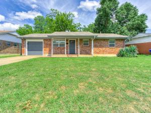a brick house with a lawn in front of it at Norman Home with Game Room in Norman