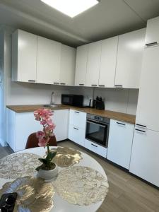 a kitchen with a table with a vase of flowers on it at Bedugnės Namelis in Vilnius