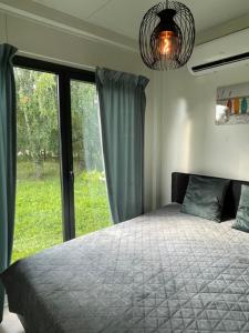 a bedroom with a bed and a large window at Bedugnės Namelis in Vilnius