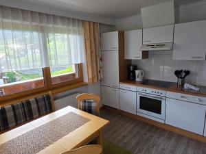 a kitchen with white appliances and a wooden table at Siegele - Top 1 in Kappl