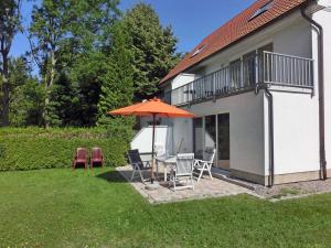 a patio with a table and chairs and an umbrella at Fährhof 6b EG in Wiek auf Rügen +3 photos