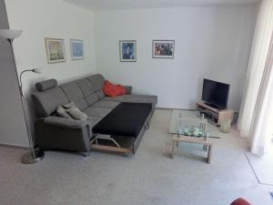 a living room with a couch and a tv at Fährhof 6b EG in Wiek auf Rügen