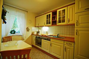 a kitchen with white cabinets and a table and a sink at Fährhof 6b EG in Wiek auf Rügen