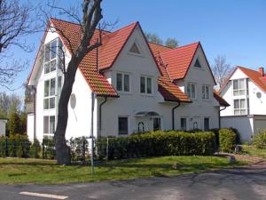 a large white house with an orange roof at Fährhof 6b EG in Wiek auf Rügen