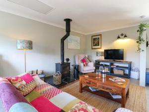 a living room with a couch and a wood stove at The Annexe Shotley Cottage in Ipswich