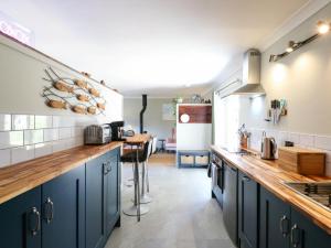a kitchen with blue cabinets and a counter top at The Annexe Shotley Cottage in Ipswich