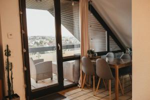 a dining room with a table and chairs and a balcony at Ferienwohnung Südblick in Barntrup