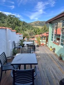 a patio with tables and chairs on a wooden deck at A Estalagem Pousada in Monteiro Lobato