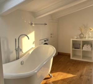a white bath tub in a bathroom with a sink at Poggio Madonna in Campagnatico +47 photos