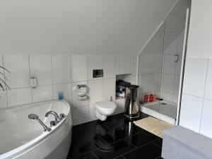 a bathroom with a tub and a toilet and a sink at Studio Mel in Mülheim an der Ruhr