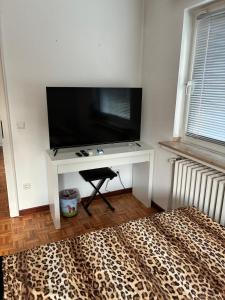 a white desk with a flat screen tv on a wall at Studio Mel in Mülheim an der Ruhr