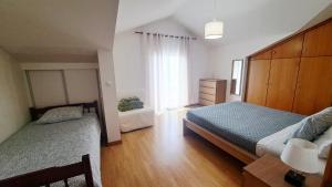 a bedroom with two beds and a large window at Villa Abreu in Ponta do Sol