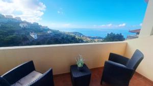 a balcony with chairs and a view of the ocean at Villa Abreu in Ponta do Sol