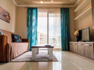 a living room with a couch and a table and a tv at Riviera Holiday Apartments - Seafront - Wifi in Marsaskala