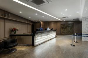 two men standing at the reception counter of a hotel lobby at Hotel D'sintra in Balneário Camboriú +29 photos