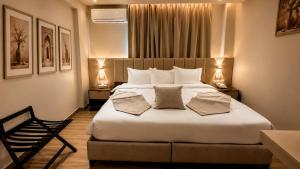 a bedroom with a large white bed with two lamps at Sama Al Sweifieh - سما الصويفية in Amman +6 photos