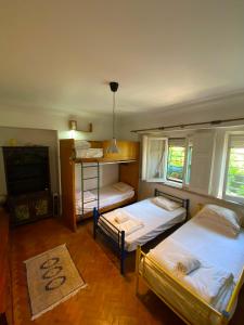 a room with two beds and a tv and a room with at Botanique Guesthouse in Cascais