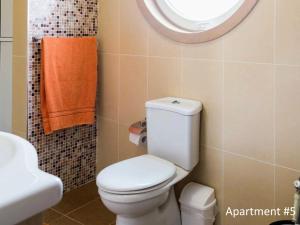 a bathroom with a toilet and a sink and a mirror at Riviera Holiday Apartments - Seafront - Wifi in Marsaskala +10 photos