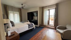 a bedroom with a bed and a tv and a chair at Mision Catedral Morelia in Morelia
