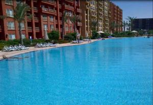 a large swimming pool in front of a building at Cozy chalet in El Alamein