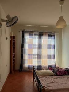 a bedroom with a bed and a plaid curtain at Cozy chalet in El Alamein