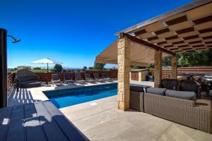 a patio with a swimming pool and a pavilion at Modern Villa HG08 Pyrinas with Amazing Golf Views, in heart of Aphrodite Hills in Kouklia