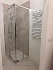 a shower stall with glass doors in a bathroom at Scirocco - ideale per coppie e famiglie in Carmiano