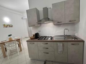 a kitchen with a sink and a stove top oven at Scirocco - ideale per coppie e famiglie in Carmiano