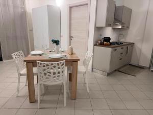 a kitchen with a wooden table and chairs in a kitchen at Scirocco - ideale per coppie e famiglie in Carmiano +32 photos