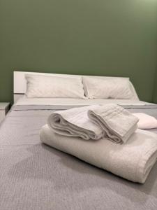 a bed with white blankets and pillows on it at Scirocco - ideale per coppie e famiglie in Carmiano