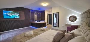 a bedroom with a bed and a bathroom with a sink at Jezero Rudanka in Doboj