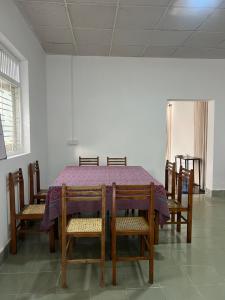 a dining room table with chairs and a purple table cloth at Lake Hostel Anuradhapura in Anuradhapura