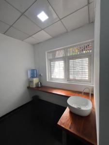 a room with a table and a window with a sink at Lake Hostel Anuradhapura in Anuradhapura