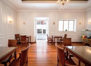 a dining room with tables and chairs and a chandelier at Patrimonial Hotel Boutique in Cochabamba