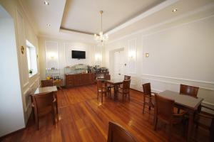 a dining room with tables and chairs and a television at Patrimonial Hotel Boutique in Cochabamba